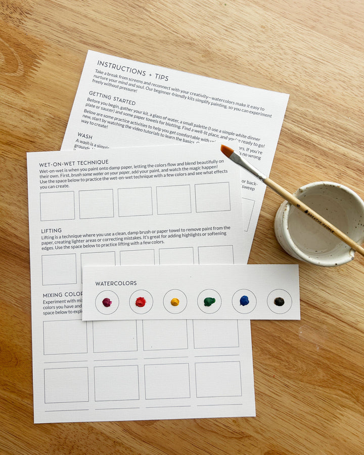 Instructional materials for watercolor painting on a wooden surface