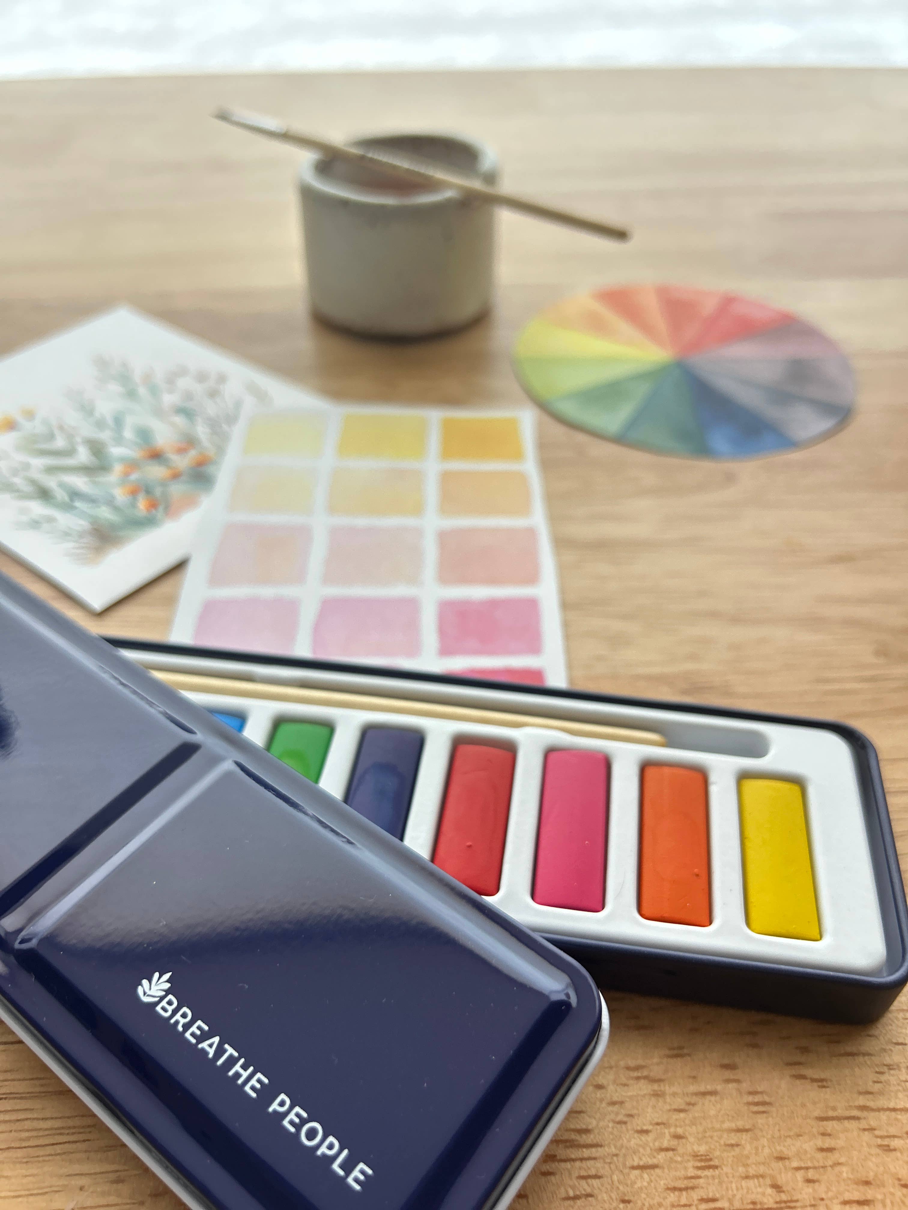 Set of watercolor paints with a color wheel and paintbrush