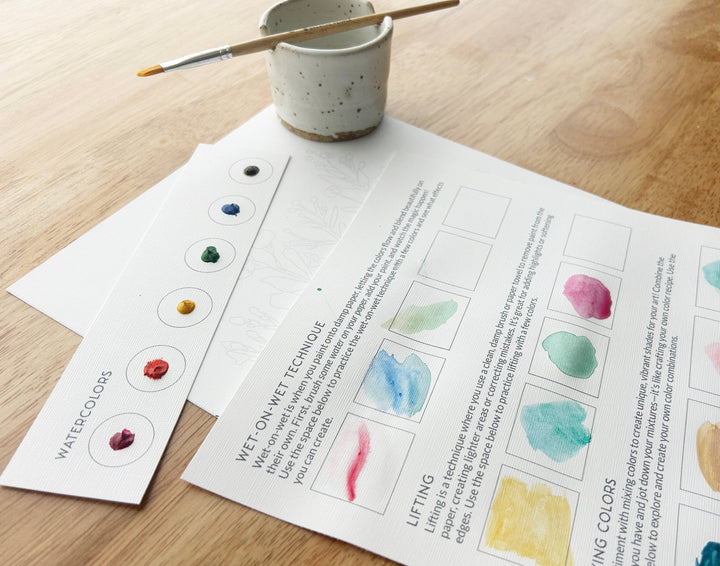 Instructional materials on watercolor techniques with a cup and brush