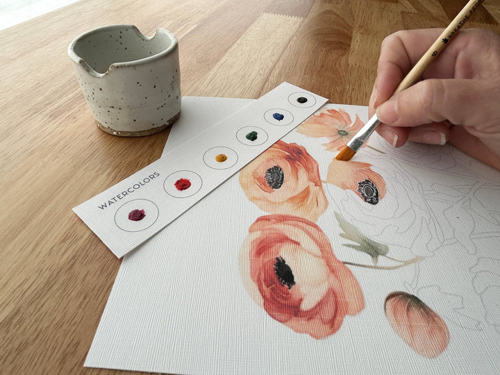 Person painting flowers with watercolors