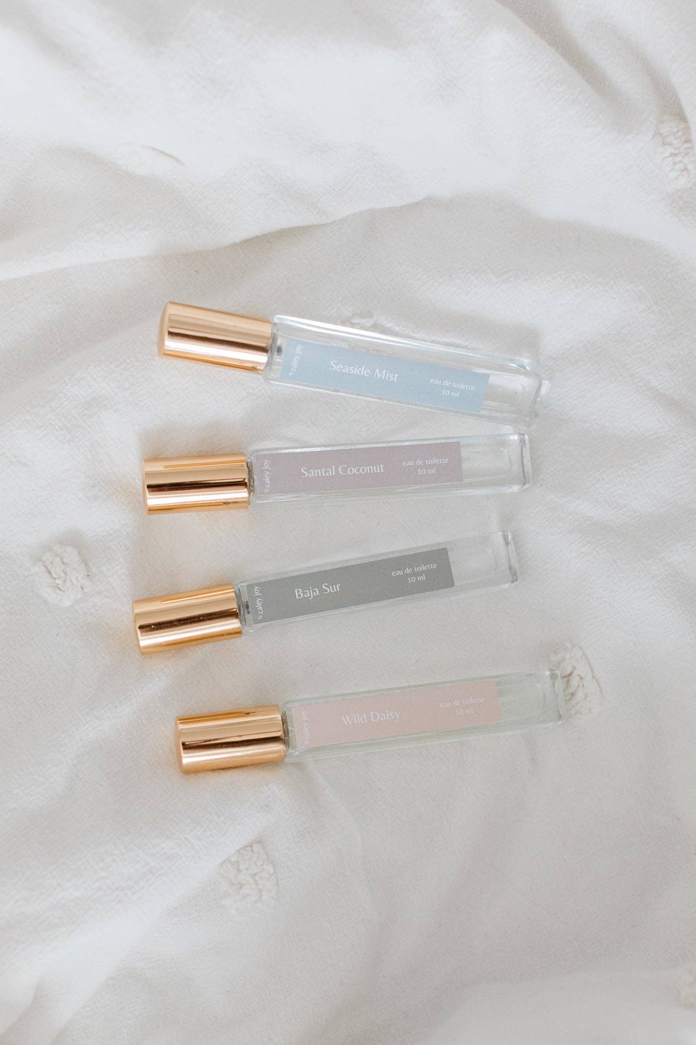 Four transparent lip gloss tubes with gold caps