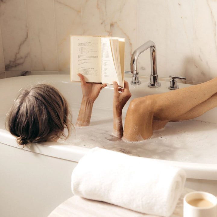 Person reading a book in a bathtub