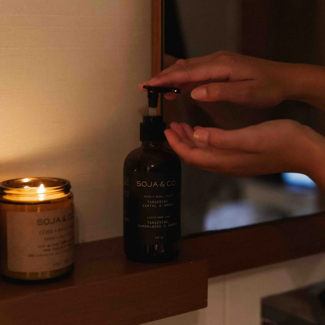 Person using a pump bottle labeled 'SOJA & CO'