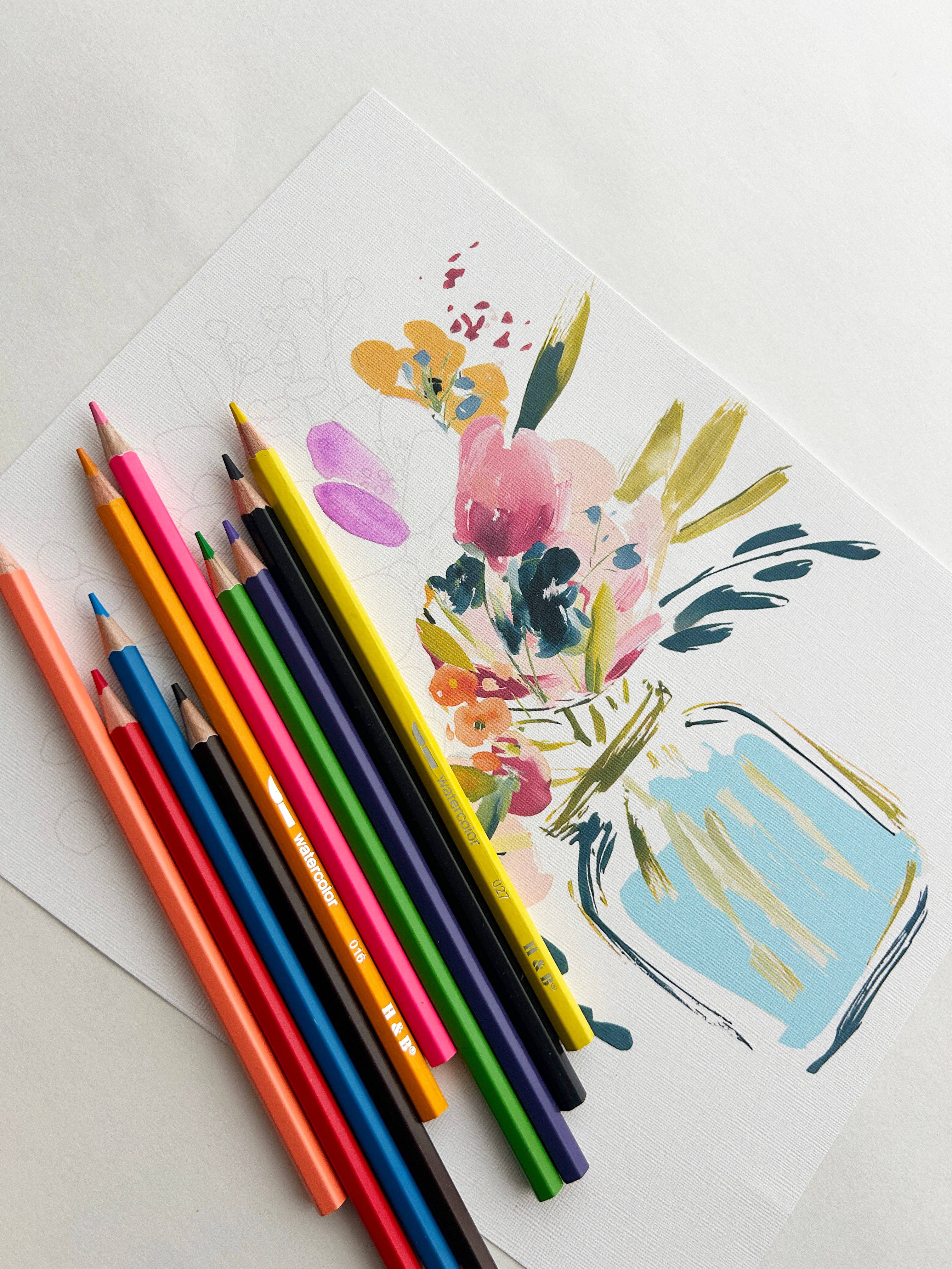 Colorful pencils on a white surface with a floral illustration of a jar.