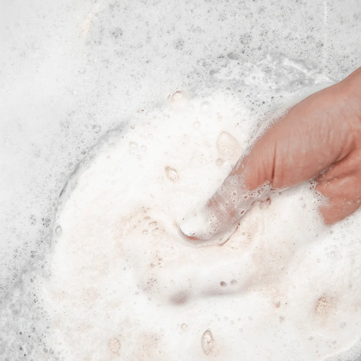 Hand interacting with soapy water