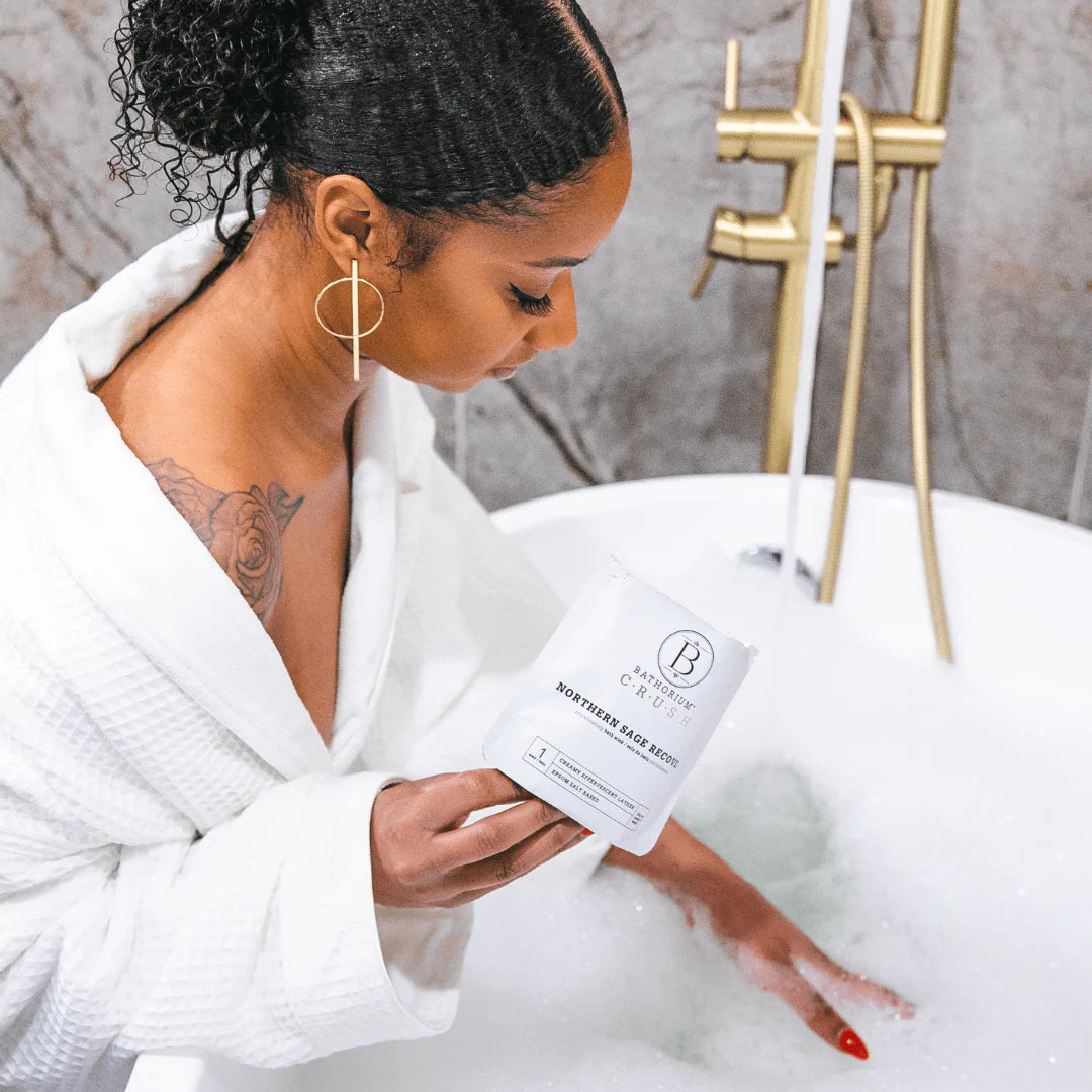 Woman in a white robe holding a product