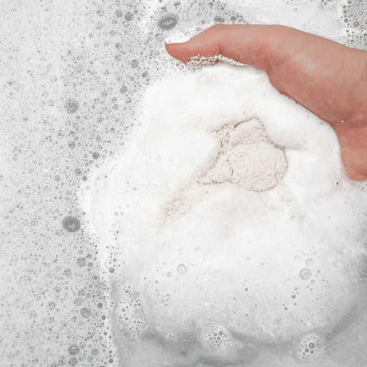 Hand holding a ball of white foam with bubbles