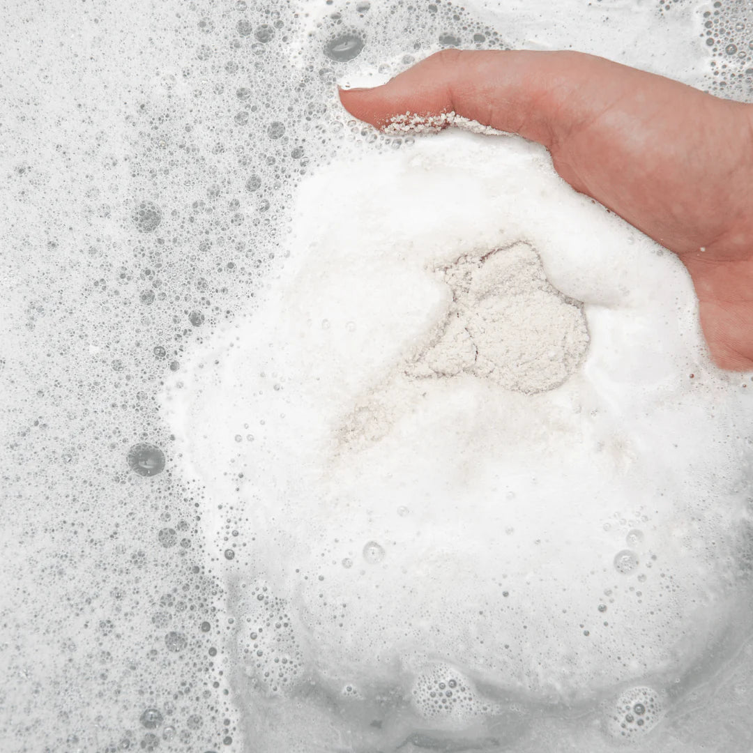 Hand holding a ball of white foam with bubbles