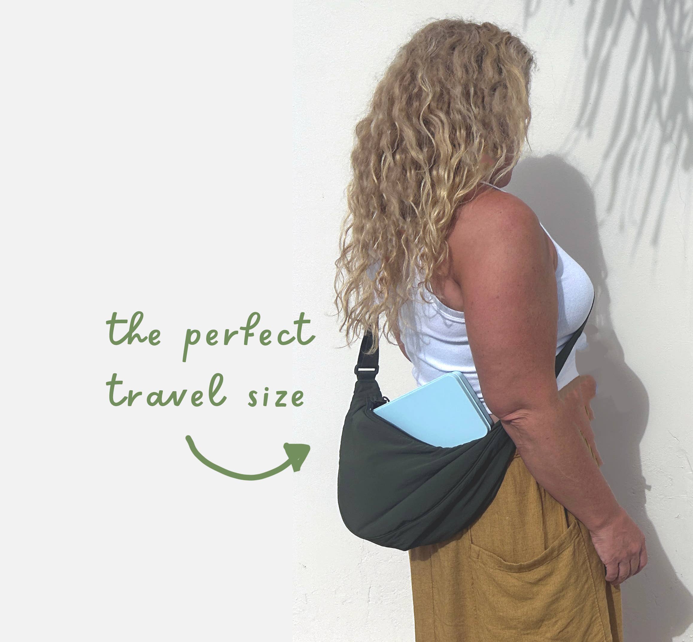 Woman with a black crossbody bag holding a blue item