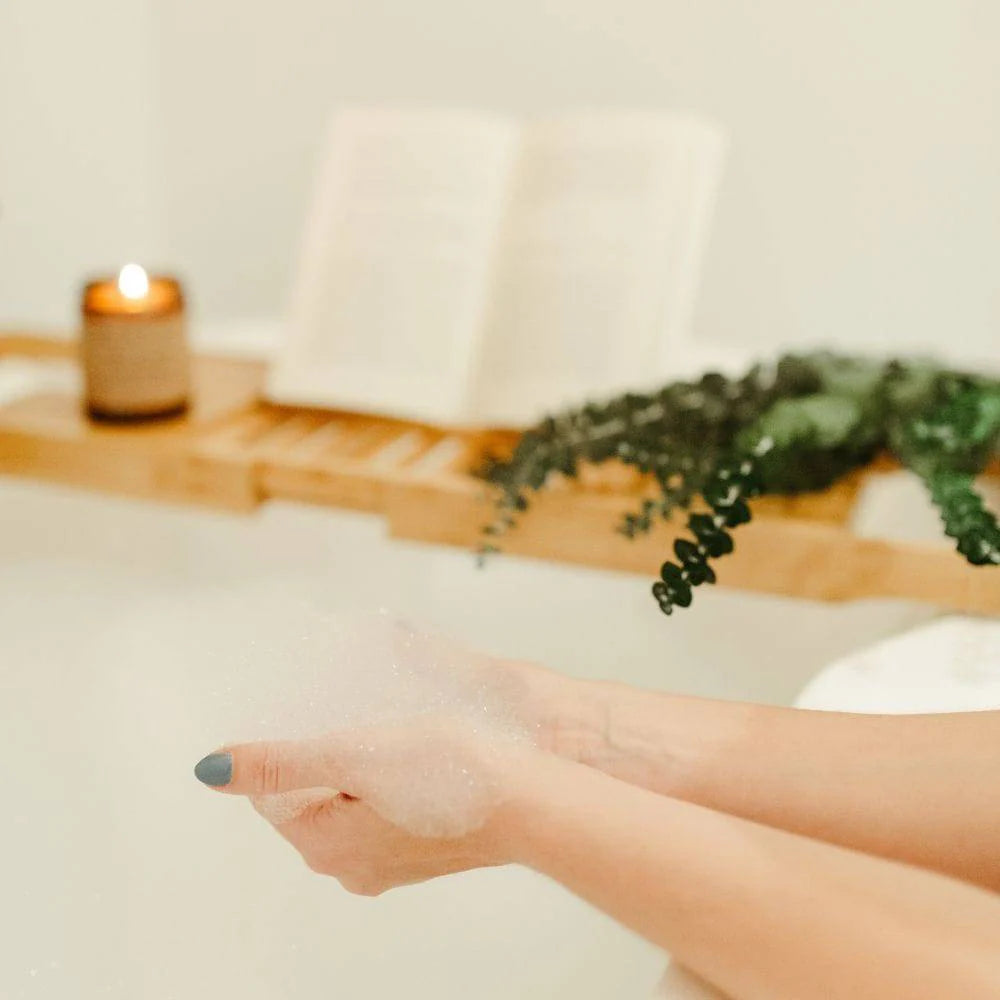 Person's hand with bubbles in a bathtub