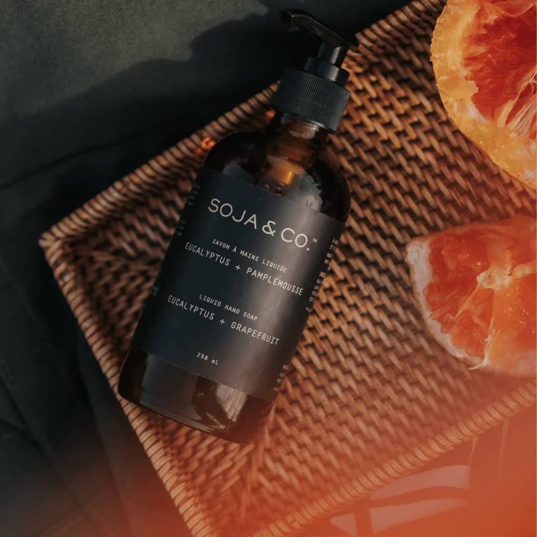 Bottle of SOJA & CO. liquid soap on a textured surface
